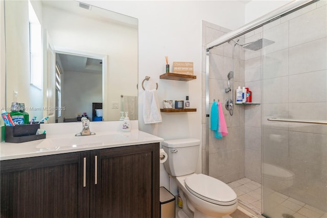 bathroom featuring vanity, a shower with door, and toilet