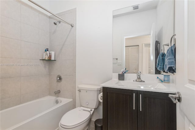 full bathroom with tiled shower / bath, vanity, and toilet