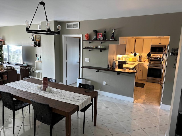 dining room featuring sink, light tile patterned flooring, and a chandelier