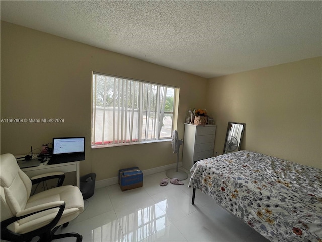 bedroom with a textured ceiling and light tile patterned floors