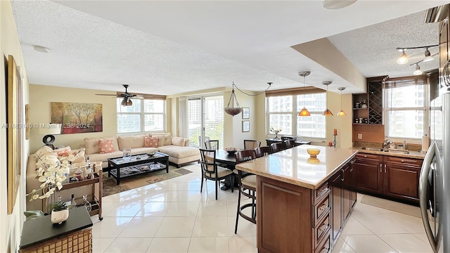 kitchen featuring a wealth of natural light, a textured ceiling, and light tile patterned flooring