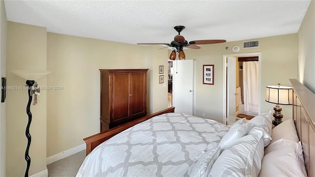 bedroom with ceiling fan, a textured ceiling, and light colored carpet