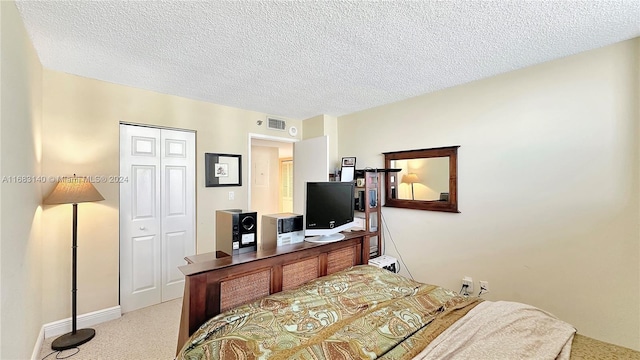 bedroom featuring a closet, a textured ceiling, and light carpet