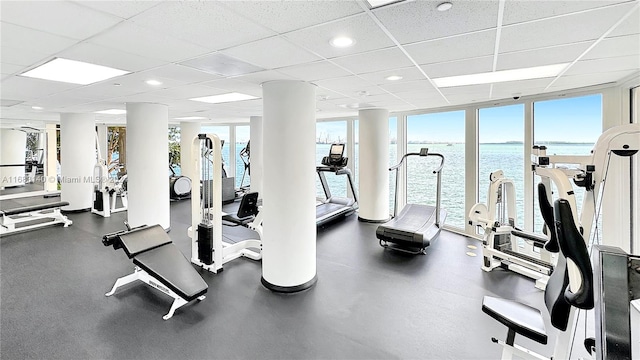 exercise room with a water view and a drop ceiling