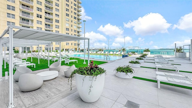 view of patio with a water view and a community pool