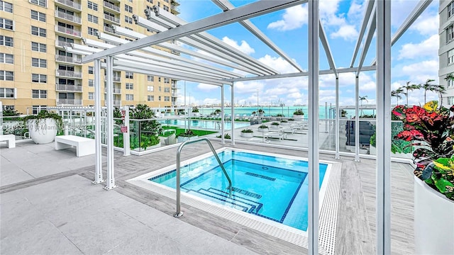 view of pool with a hot tub and a water view