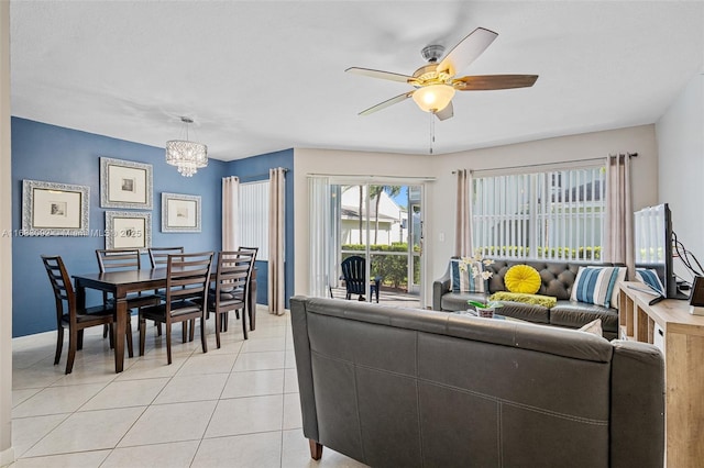 living room featuring ceiling fan with notable chandelier, a healthy amount of sunlight, and light tile patterned floors