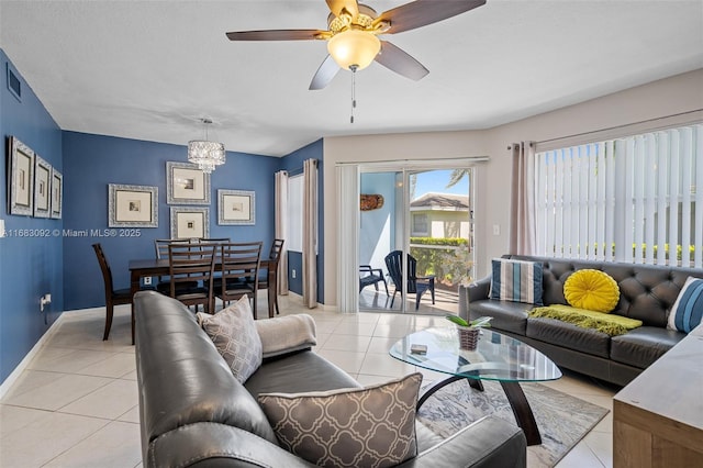 tiled living room featuring ceiling fan with notable chandelier