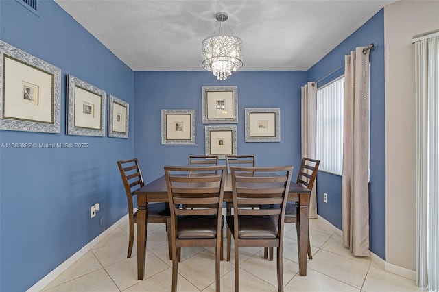 tiled dining room featuring a textured ceiling and a notable chandelier