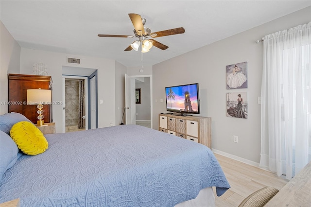 bedroom with ensuite bath, ceiling fan, and light hardwood / wood-style floors