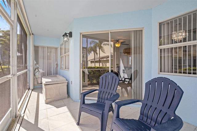 sunroom / solarium with ceiling fan with notable chandelier