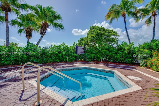 view of swimming pool featuring a hot tub