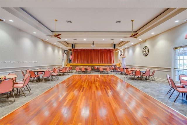 misc room featuring a tray ceiling, ceiling fan, and light hardwood / wood-style flooring