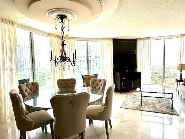 dining room featuring a raised ceiling, expansive windows, light tile patterned flooring, and a textured ceiling