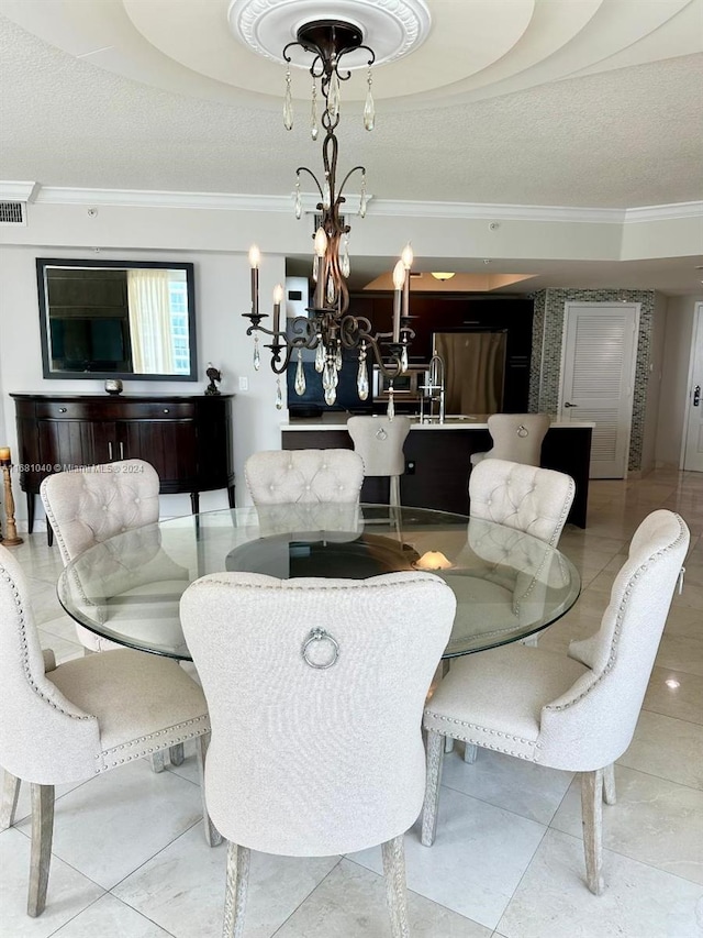 tiled dining area featuring crown molding, a textured ceiling, and an inviting chandelier