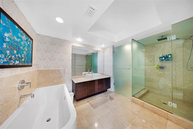 bathroom with vanity, a raised ceiling, tile walls, and separate shower and tub