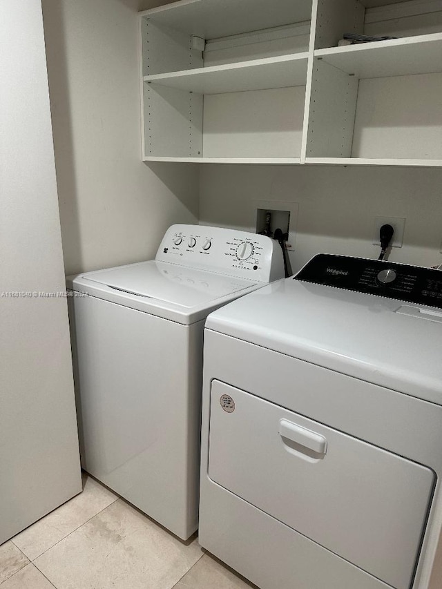 washroom featuring washer and clothes dryer and light tile patterned floors