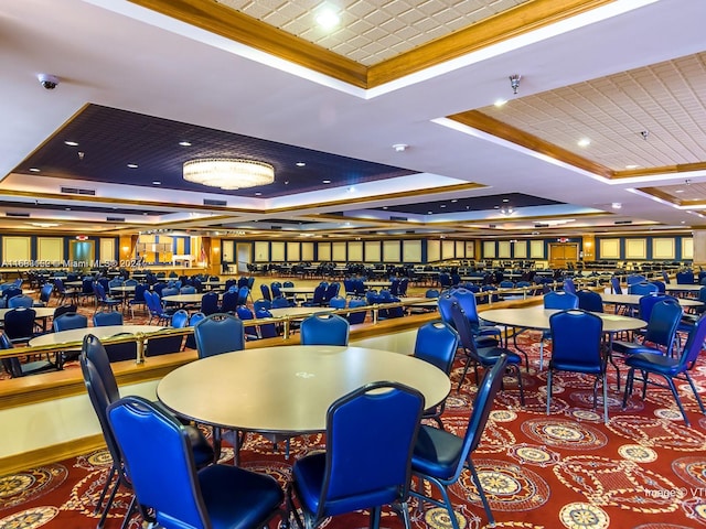 carpeted dining room featuring a raised ceiling and crown molding