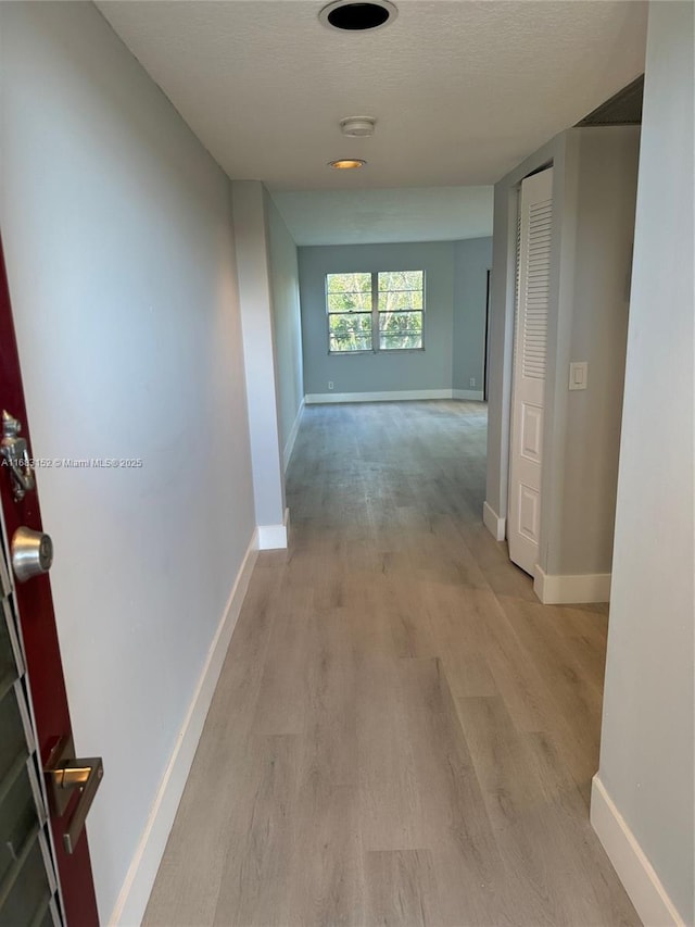 12800 SW 7th Ct Unit 313G, Pembroke Pines, FL 33027 - hall featuring light wood-type flooring, baseboards, and a textured ceiling