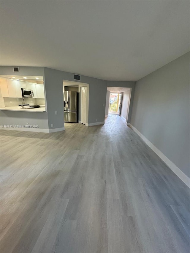 12800 SW 7th Ct Unit 313G, Pembroke Pines, FL 33027 - unfurnished living room featuring wood finished floors and baseboards