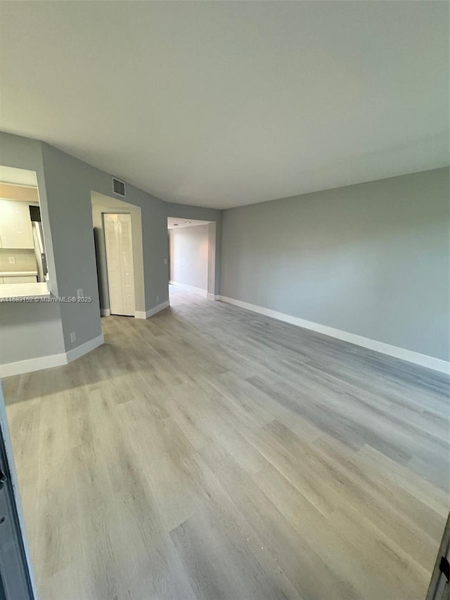 12800 SW 7th Ct Unit 313G, Pembroke Pines, FL 33027 - unfurnished living room featuring light wood finished floors and baseboards