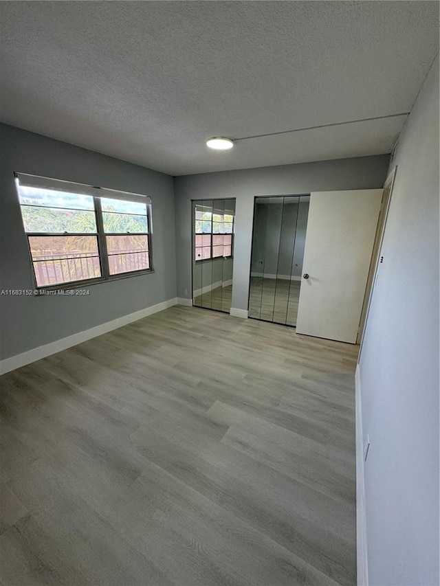 empty room featuring light hardwood / wood-style floors and a textured ceiling