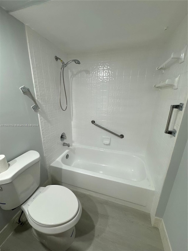 bathroom featuring toilet and tiled shower / bath