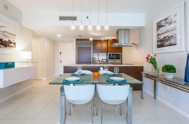 485 Brickell Ave Unit 3906, Miami, FL 33131 - kitchen featuring island exhaust hood, built in appliances, baseboards, and light tile patterned floors