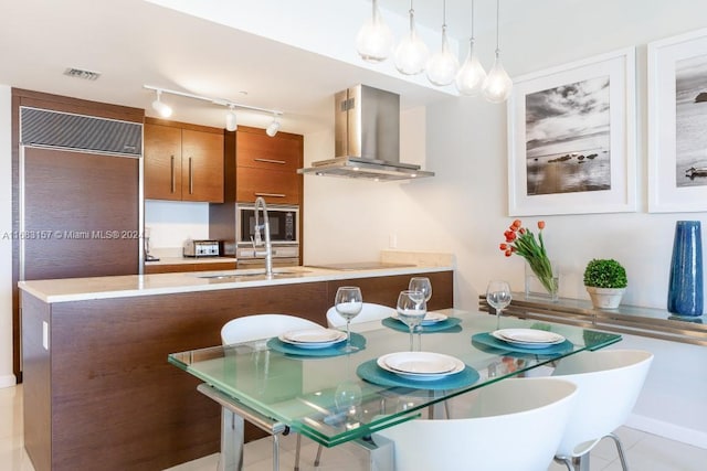 dining area featuring rail lighting and light tile patterned floors