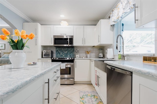2610 SW 16th St, Fort Lauderdale, FL 33312 - kitchen with ornamental molding, white cabinets, a sink, backsplash, and stainless steel appliances