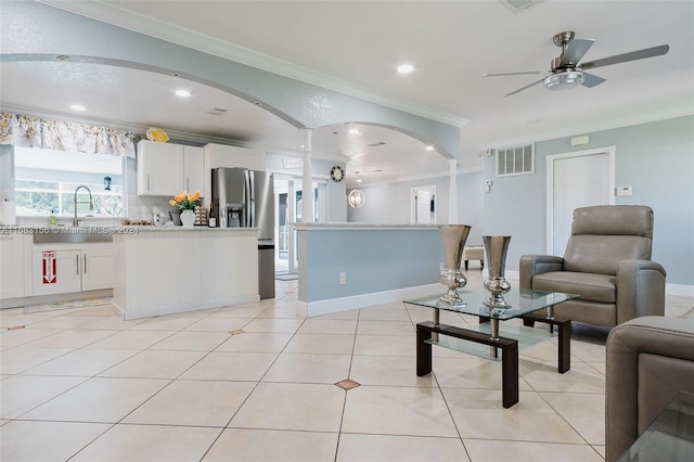 tiled living room with crown molding and sink