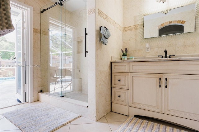 bathroom featuring tile walls, vanity, a shower with shower door, and tile patterned floors