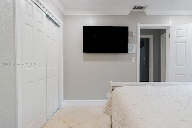 tiled bedroom featuring a closet and ornamental molding