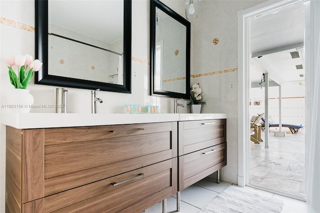 bathroom featuring vanity and tile walls