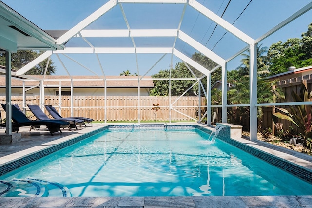 view of swimming pool featuring pool water feature, a patio area, and a lanai