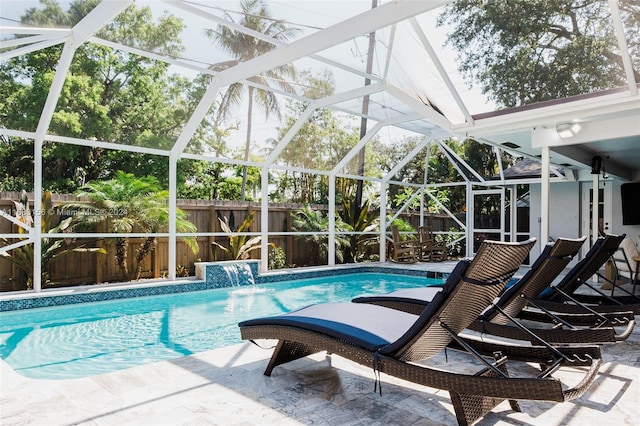 view of pool with pool water feature, a patio, and glass enclosure