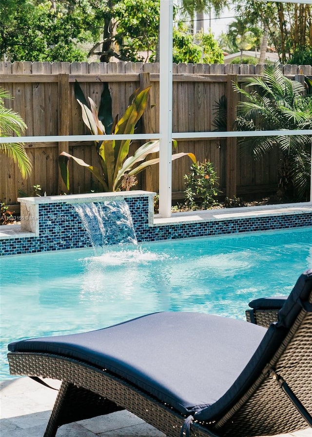 view of swimming pool with pool water feature