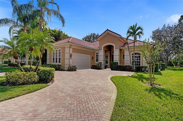 mediterranean / spanish house with a garage and a front yard