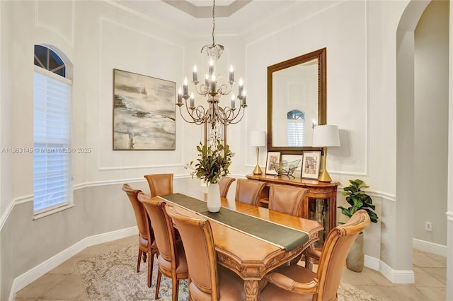 dining room featuring ornamental molding, light tile patterned floors, and a notable chandelier