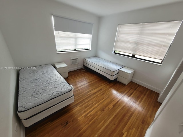 bedroom featuring a wall mounted air conditioner and dark hardwood / wood-style floors