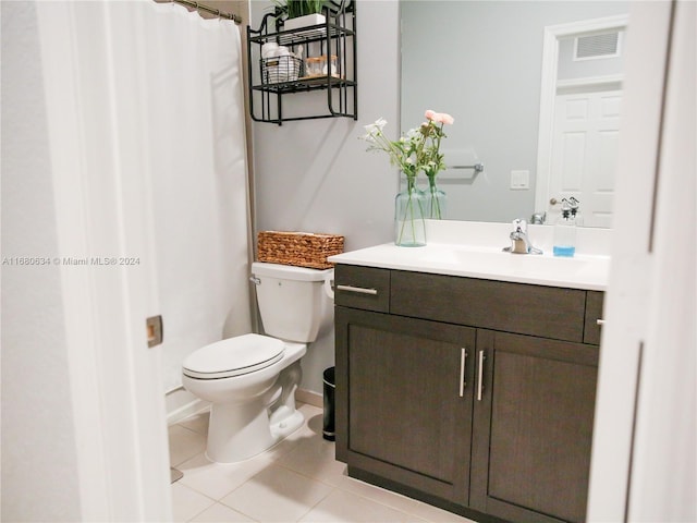 bathroom with vanity, toilet, walk in shower, and tile patterned flooring