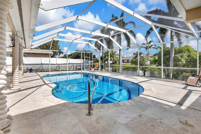 view of pool featuring a patio area, a lanai, and a water view