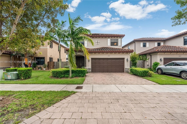 mediterranean / spanish house featuring a front lawn and a garage