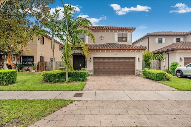 mediterranean / spanish-style house featuring a front yard and a garage