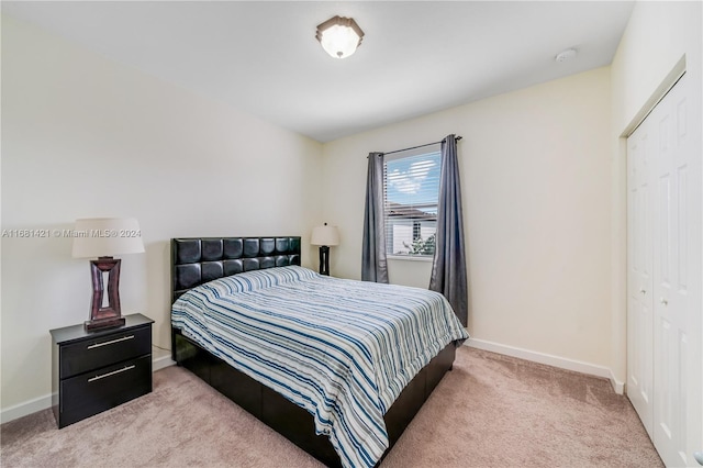 bedroom with light carpet and a closet