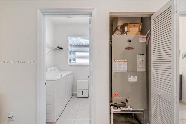 laundry area featuring heating unit, washing machine and dryer, and light tile patterned floors