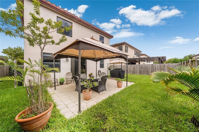 back of property with a gazebo, a yard, and a patio