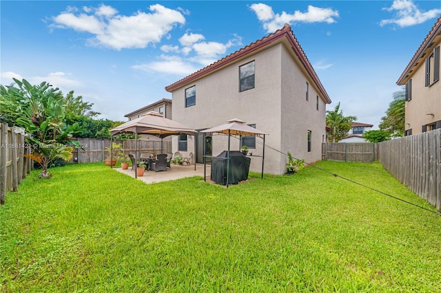 rear view of house featuring a patio, a gazebo, and a lawn