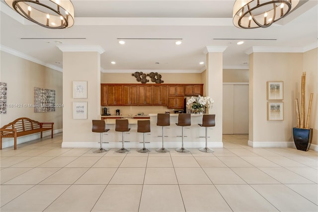 kitchen featuring an inviting chandelier, ornamental molding, and a kitchen bar