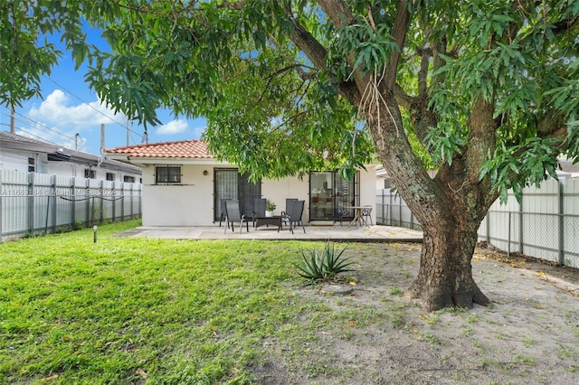 back of property with a patio and a lawn